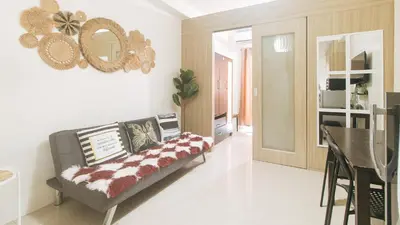 a living room with a couch and a dining room at Lascianos SMDC Shore Residences by RedDoorz in Manila