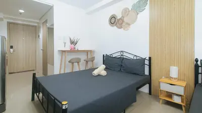 a bedroom with a bed with a blue comforter at Lascianos SMDC Shore Residences by RedDoorz in Manila