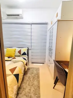 a small bedroom with a bed and a desk at Fame Residence Tower 1 Cozy Hotel Style 1 Bedroom with Balcony pool View in Manila