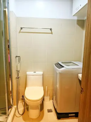 a small bathroom with a toilet and a shower at Fame Residence Tower 1 Cozy Hotel Style 1 Bedroom with Balcony pool View in Manila