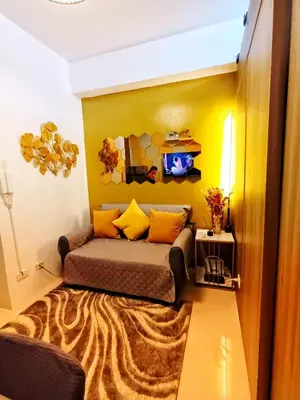 a bedroom with a bed and a yellow wall at Fame Residence Tower 1 Cozy Hotel Style 1 Bedroom with Balcony pool View in Manila