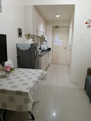 a small kitchen with a table and a refrigerator at Eriel condotel in Manila