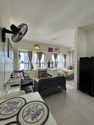 a living room with a couch and a table at Perfect accommodation for you in Levels Burbank in Manila