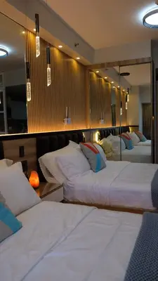 a hotel room with two beds and a mirror at Air Residence Makati Suite Sophisticated Living Condo 300 Mbps in Manila