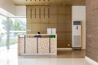 a man sitting at a counter in a lobby at Levels Executive Residences in Manila