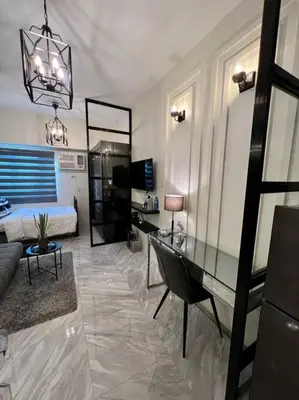 a living room with a bed and a desk in it at Luxury Style Living-Netflix Ready in Manila