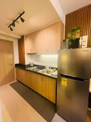 a kitchen with a stainless steel refrigerator and a sink at Alonas Residences in Manila