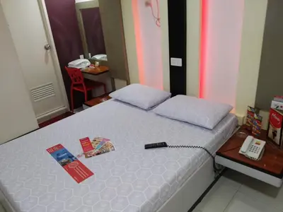 a bedroom with a bed with a remote control on it at Hotel Sogo - EDSA, Pasay Harrison in Manila
