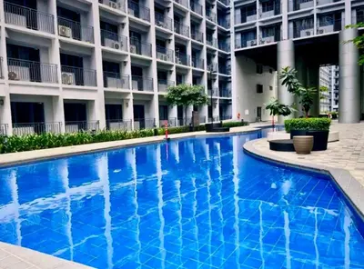 a large blue swimming pool in front of a building at Hotel-Like Staycation2 MOA Pasay in Manila