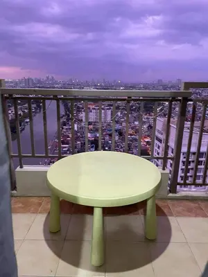 a table on a balcony with a view of a city at Tivoli Garden Residences, 1 Bedroom unit with sunset view in Manila