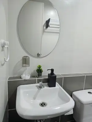 a bathroom with a white sink and a mirror at 5F J Phase1 Sevilla in Manila