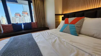 a bedroom with a white bed with a large window at Makati Air Luxury Package - Laugh Sleep Brunch Surf 300 mbps Fast in Manila