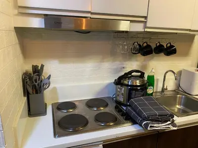 a stove top with a tea pot on it next to a sink at Makati Air Luxury Package - Laugh Sleep Brunch Surf 300 mbps Fast in Manila