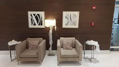 a living room with two chairs and a lamp at Covent Garden South Residences in Manila