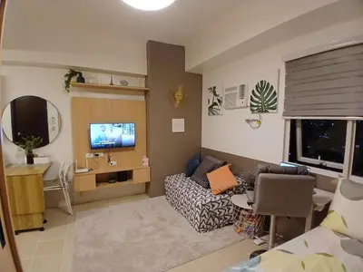 a living room with a couch and a tv in it at Covent Garden South Residences in Manila