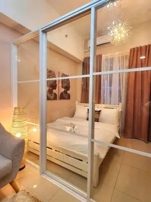 a bedroom with a bed with a glass wall at Payapa Staycation by DC in Manila