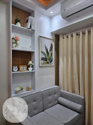 a living room with a couch and a table at MZ Suite Home at SMDC Charm Residences in Manila