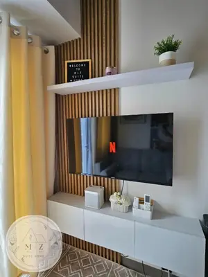 a living room with a flat screen tv on a wall at MZ Suite Home at SMDC Charm Residences in Manila