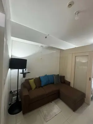 a living room with a brown couch in a room at Makati Jazz Staycation in Manila