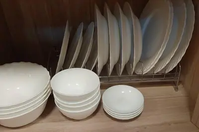 four white plates and bowls on a shelf at Helaena's Scandi Haven in Manila
