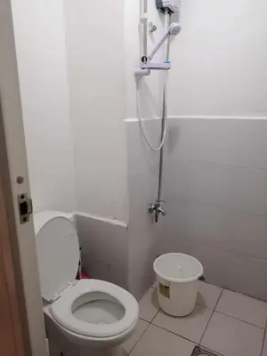 a small bathroom with a toilet and a shower at Dens condotel Metro Manila in Manila