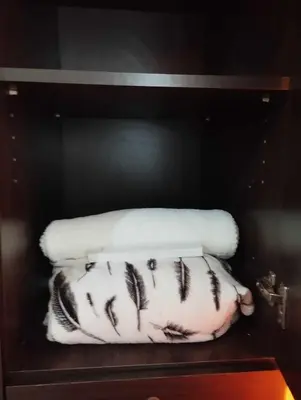 a shelf with two white towels on top of a pillow at Staycation In front of Mall of Asia Triple M in Manila