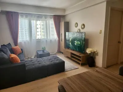 a living room with a couch and a flat screen tv at Elegant Family Retreat in the Heart of BGC in Manila