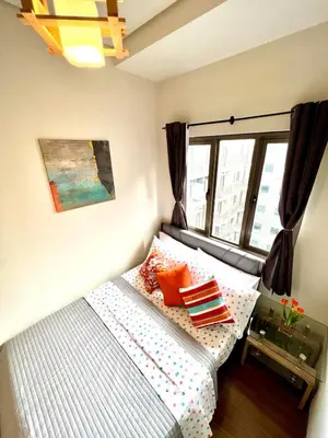 a small bed in a room with a window at Comfortable and Cozy 1BR unit near MOA in Manila