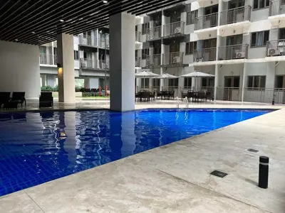 a large swimming pool in front of a building at Comfortable and Cozy 1BR unit near MOA in Manila