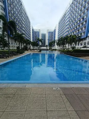 a large swimming pool in a city with tall buildings at Mall of Asia Sea Residences AMY'S Staycation in Manila