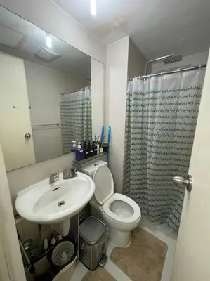 a bathroom with a sink and a toilet and a mirror at Casita Payapa - newly furnished condo unit 2nd flr in Manila