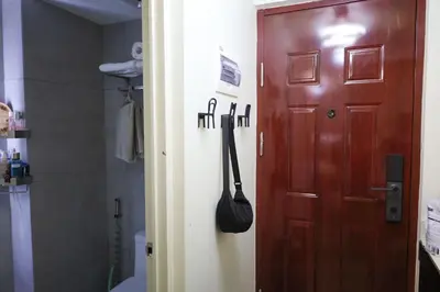 a bathroom with a door and a purse hanging on the wall at Sojourner's Suite at 605, City-view condotel near the airport at Monte Carlo Residences Charlene in Manila