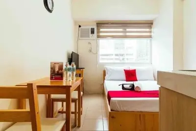 a small room with a bed and a table at Urban Deca Tower OYO in Manila