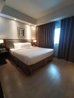 a bedroom with a large bed and a window at The Metro Nest at Bonifacio Civic Center Tower in Manila