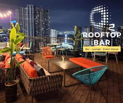 a rooftop bar with chairs and tables and a city skyline at The Metro Nest at Bonifacio Civic Center Tower in Manila