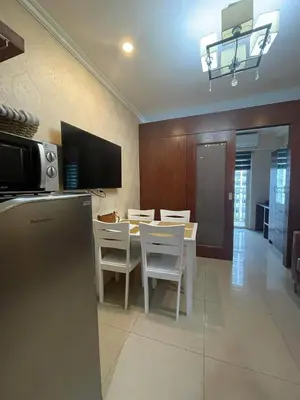 a kitchen and dining room with a table and chairs at Shore Residence Pool view Mall of Asia in Manila