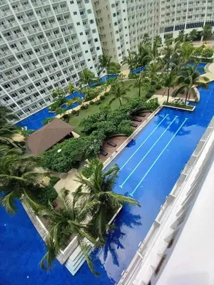arial view of a resort with palm trees and a swimming pool at Shore Residence Pool view Mall of Asia in Manila