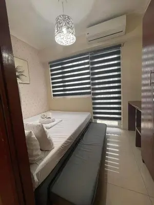 a bedroom with a bed and a window with blinds at Shore Residence Pool view Mall of Asia in Manila