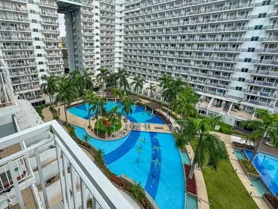 an overhead view of a large swimming pool with palm trees and buildings at 826 Air Condo Comfort Suite Spacious 1BR in Manila