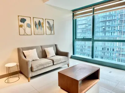 a living room with a couch and a coffee table at Cozi Uptown 1br suite Mitsukoshi Mall BGC in Manila