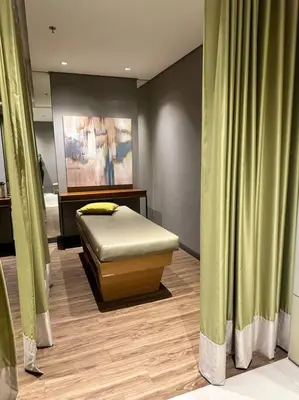a bed in a room with green curtains at Cozi Chic 1br Condo beside One uptown Mall BGC in Manila