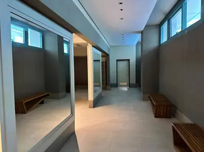 a hallway in a building with benches and windows at Cozi Chic 1br Condo beside One uptown Mall BGC in Manila