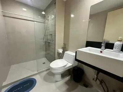 a bathroom with a toilet and a shower and a sink at COZI Venice Luxury Residences Mckinley BGC with Pool in Manila