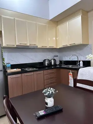 a kitchen with a table with a remote control on it at COZI Venice Luxury Residences Mckinley BGC with Pool in Manila