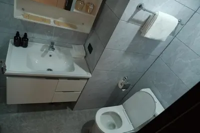 a bathroom with a white toilet and a sink at Golden Seagulls Hotel in Manila