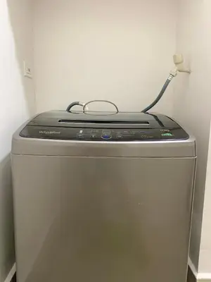 a small refrigerator with a lamp on top of it at Cozy Condominium at Amaia Steps Nuvali in Pitland