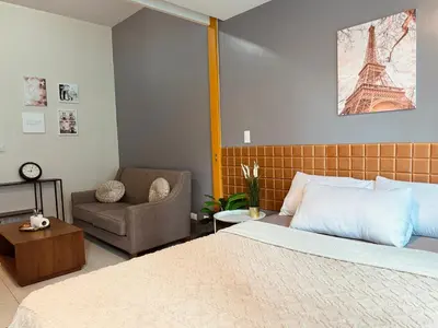 a bedroom with a bed and a chair and the eiffel tower at Cozi 1br suite Grand Hyatt BGC wifi pool in Manila