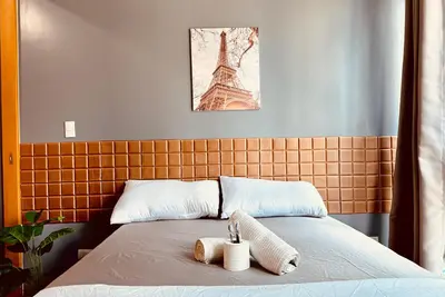 a bed with two towels and the eiffel tower at Cozi 1br suite Grand Hyatt BGC wifi pool in Manila