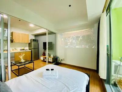 a bedroom with a white bed and a kitchen at 1 Bedroom azure beachview 3 in Manila