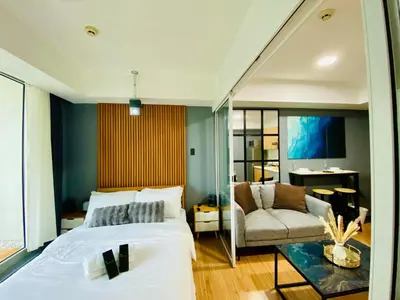 a bedroom with a large bed and a couch at 1 Bedroom azure beachview 3 in Manila